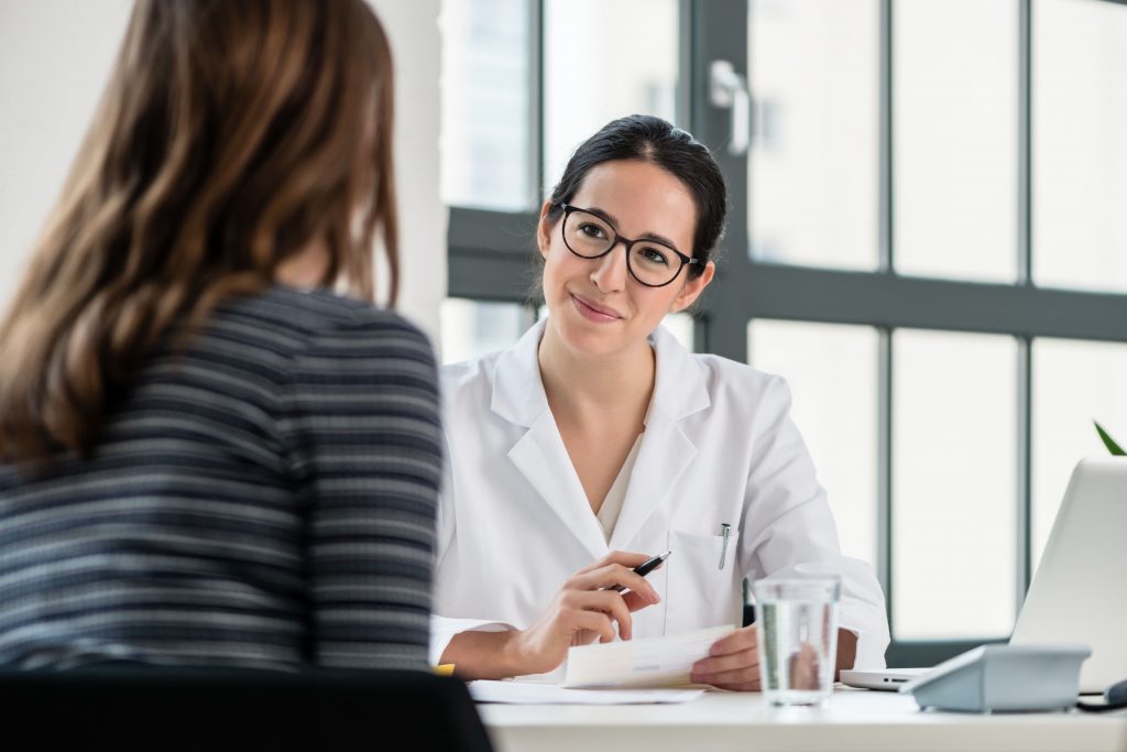 Médica conversando com paciente durante consulta para diagnóstico e tratamento do refluxo gástrico