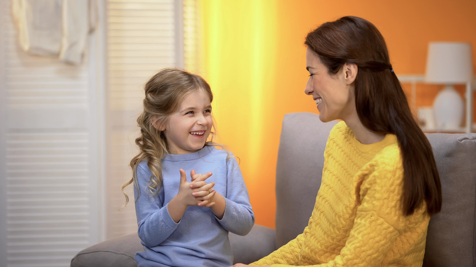Mãe conversando com filha e oferecendo apoio emocional para lidar com ansiedade infantil.